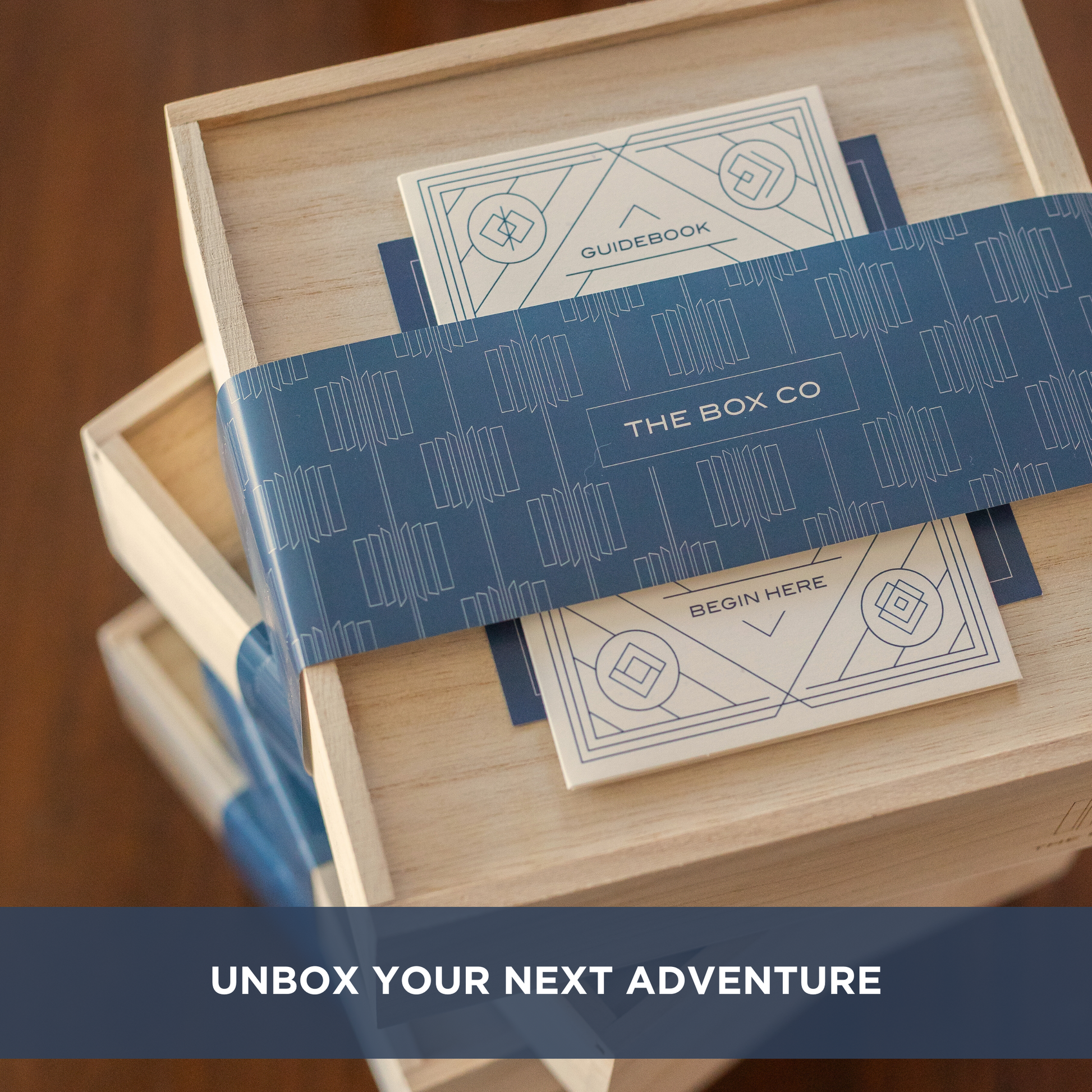 The Vision Box: a wooden box with blue wrapping. Text overlay: “UNBOX YOUR NEXT ADVENTURE".